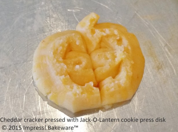 Cheddar cracker pressed with Jack-O-Lantern cookie press disk © 2015 Impress! Bakeware™